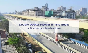 Aerial view of the double-decker flyover in Mira Road, Mumbai, with residential buildings in the background. Text overlay reads: “Double Decker Flyover In Mira Road: A Booming Infrastructure